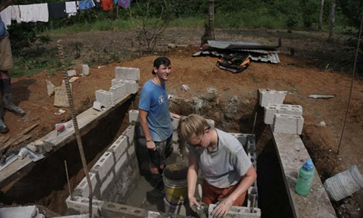 学生s working on a foundation during a mission trip